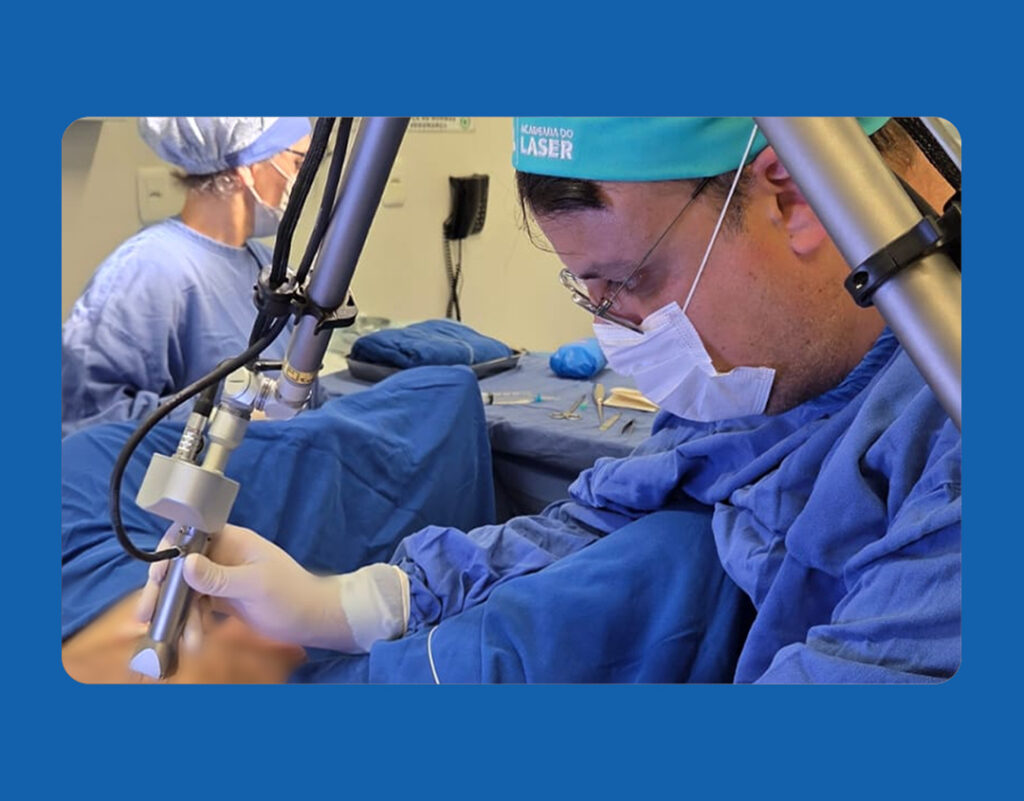 Cirurgião realizando cirurgia proctológica ambulatorial com tecnologia laser em centro cirúrgico.